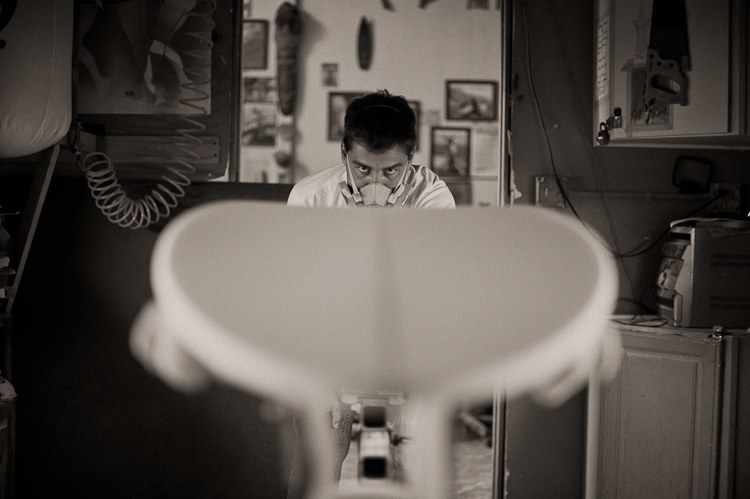 Breno Basilio checking a surfboard’s lines in the shaping bay